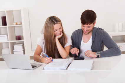 Couple faisant les comptes à l'aide d'une calculatrice et de factures couple facture calculatrice