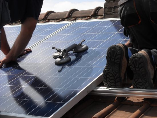 Installation de panneaux solaires sur le toit d'une maison.